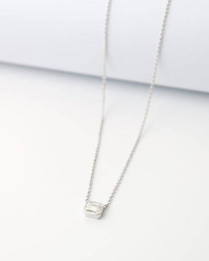 Silver necklace with a small pendant on a white background