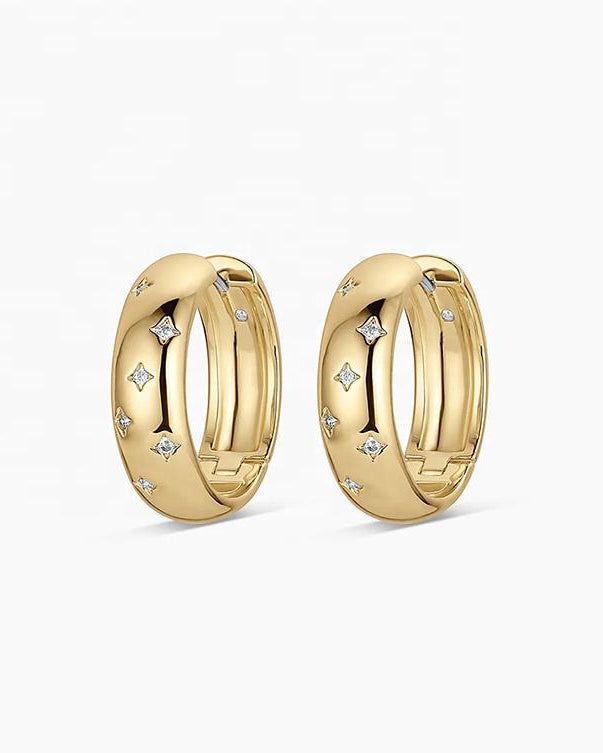 Gold plated sterling silver Solstice Huggie earrings featuring star-inspired cubic zirconia accents and a polished hinged hoop design.