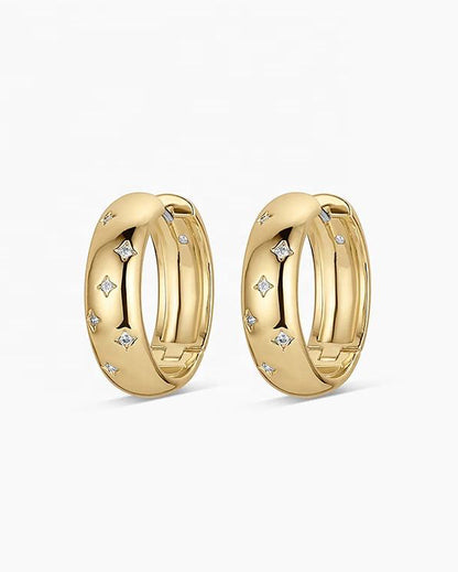 Gold plated sterling silver Solstice Huggie earrings featuring star-inspired cubic zirconia accents and a polished hinged hoop design.