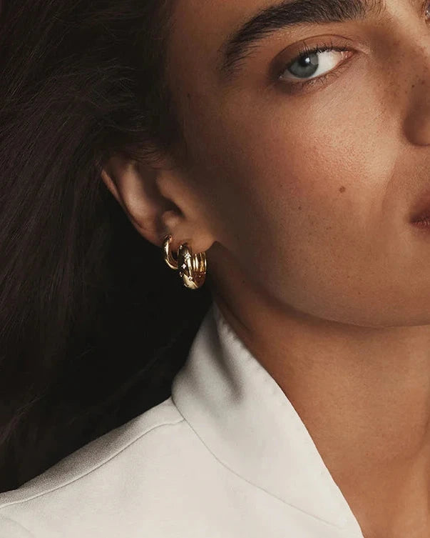 Gold plated sterling silver Solstice Huggie earrings featuring star-inspired cubic zirconia accents and a polished hinged hoop design.