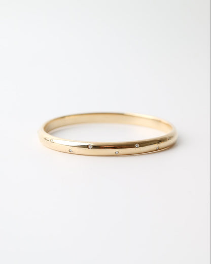 9ct yellow gold bangle with scattered lab-grown diamonds and a polished finish on a white background.