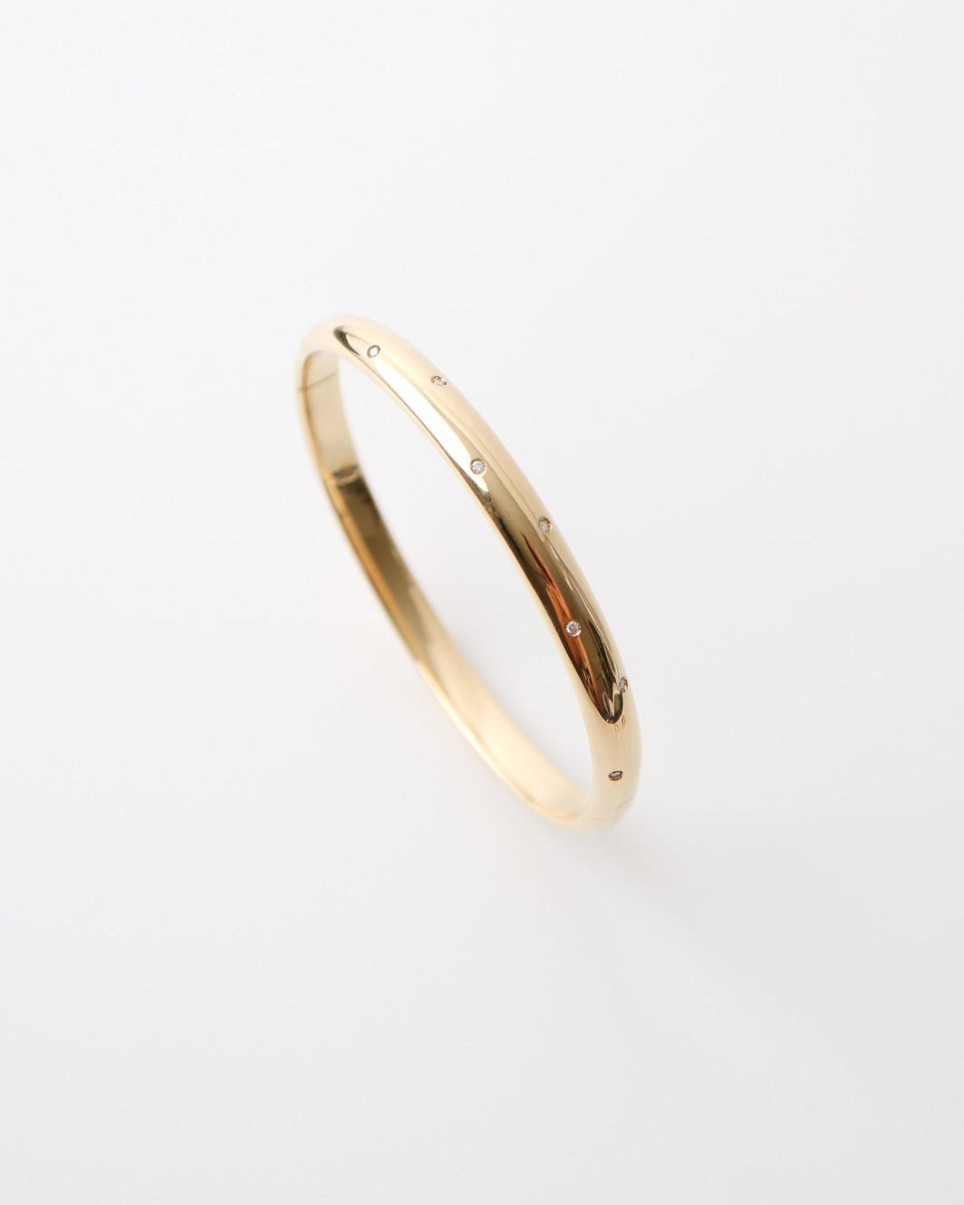 9ct yellow gold bangle with scattered lab-grown diamonds and a polished finish on a white background.