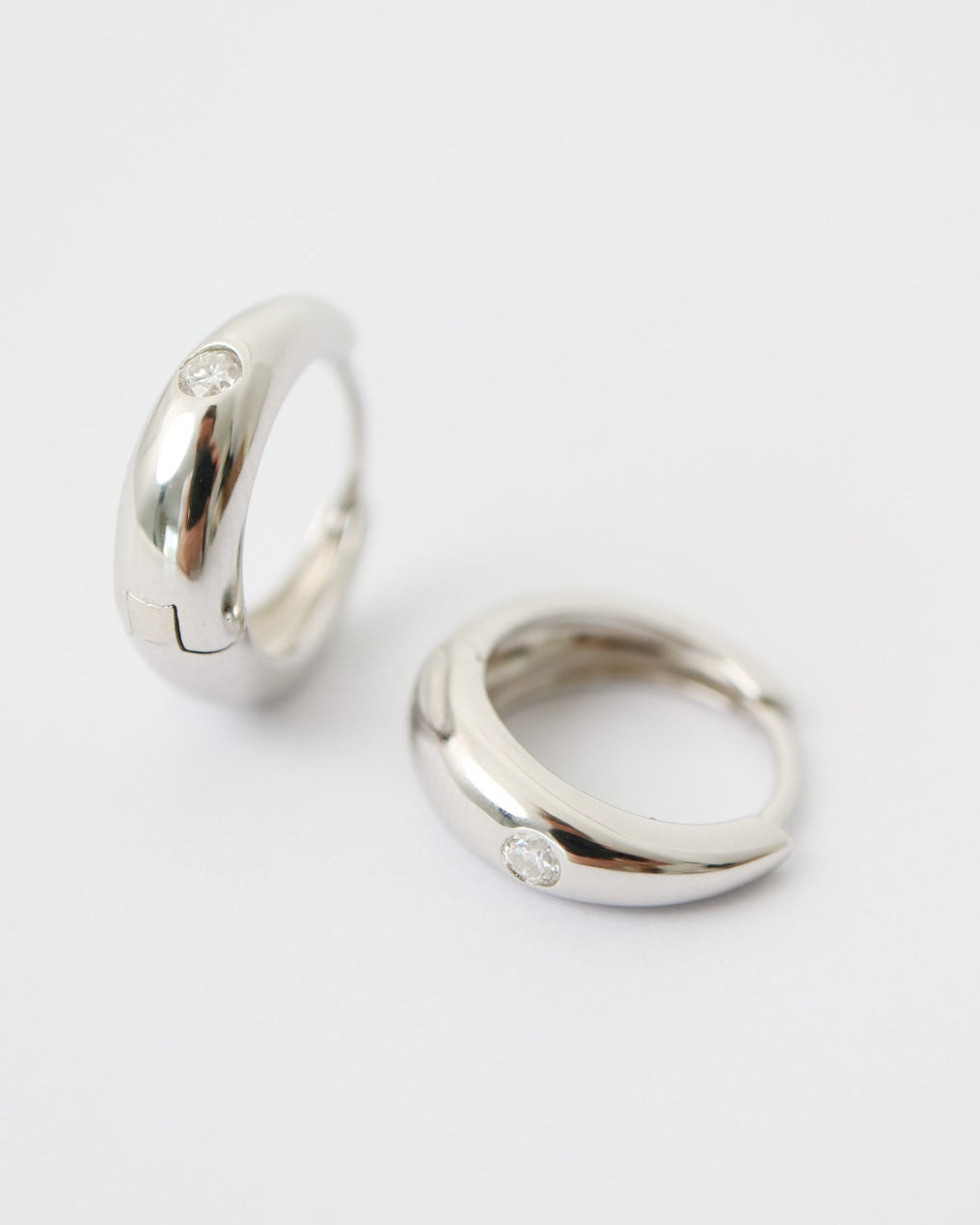 Two silver hoop earrings on a white background