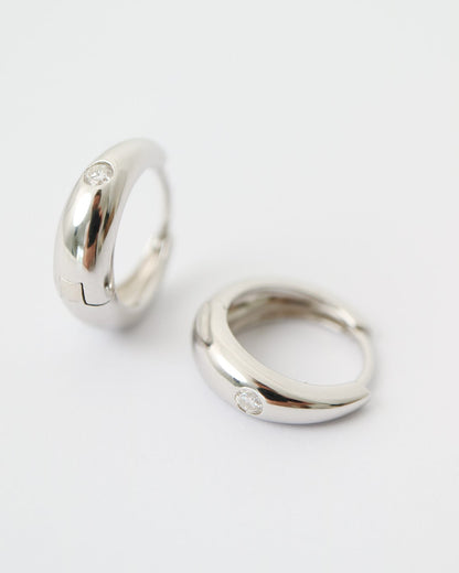Two silver hoop earrings on a white background
