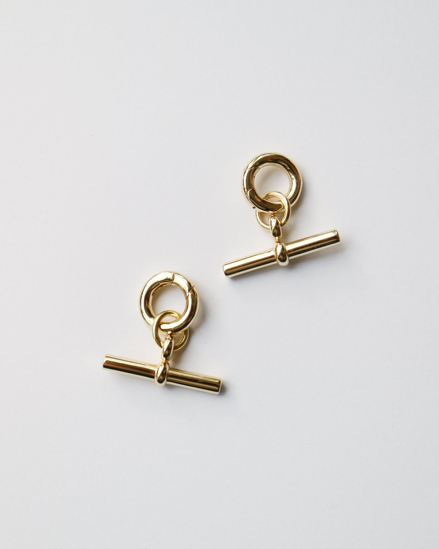 Pair of gold earrings on a light gray background