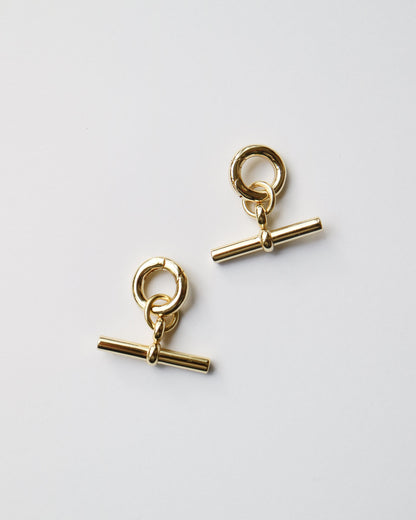 Pair of gold earrings on a light gray background