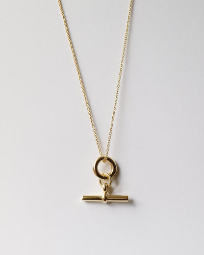 Gold necklace with a clasp on a light gray background