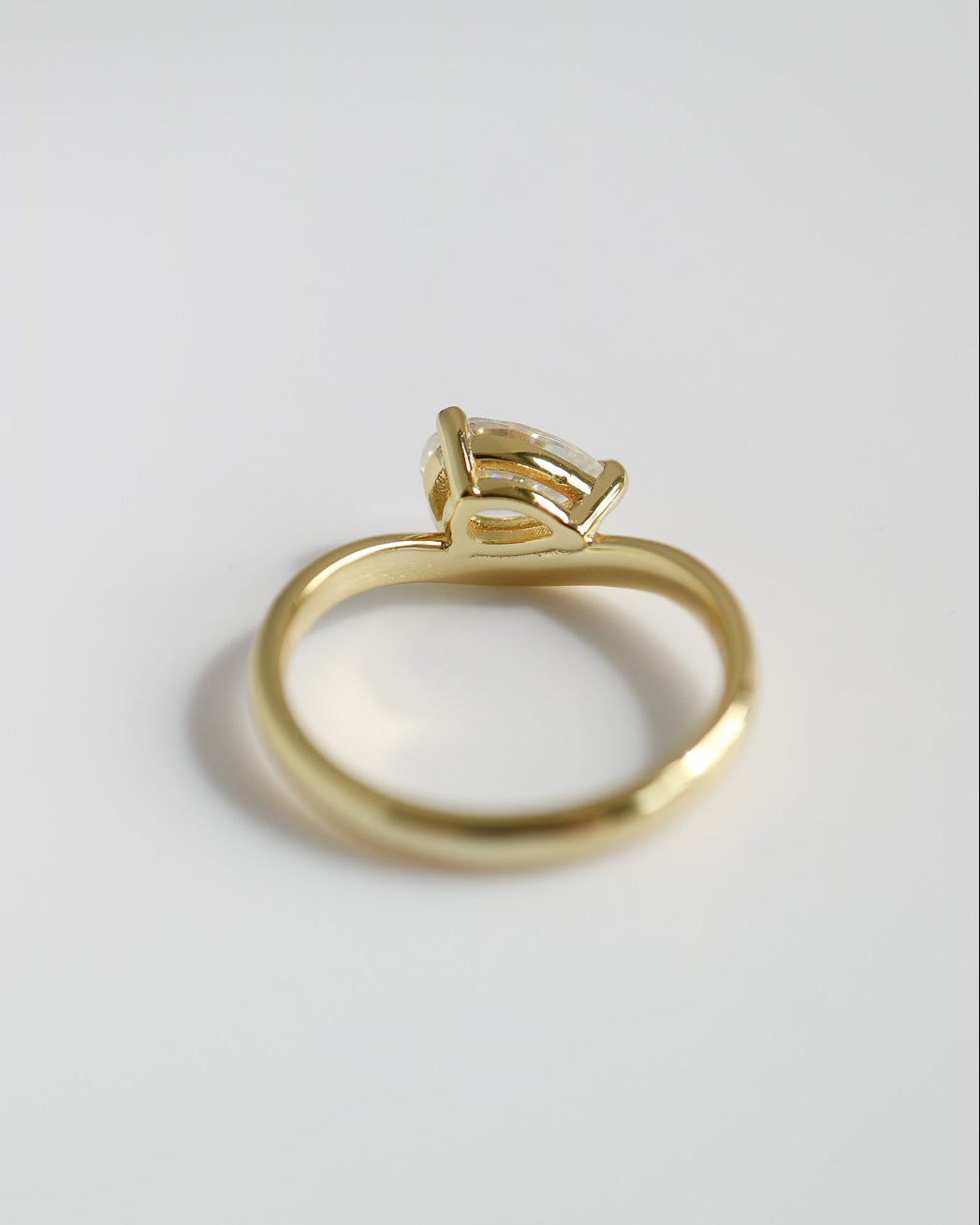 Gold ring with a diamond on a light gray background