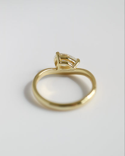 Gold ring with a diamond on a light gray background