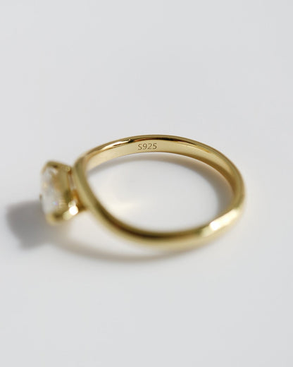 Gold ring with a diamond on a light gray background