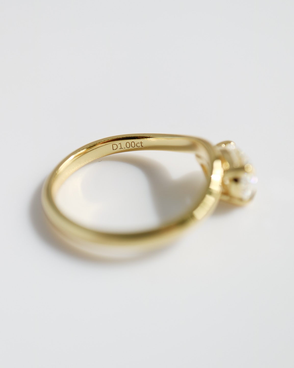 Gold ring with 'Dior' engraving on a light gray background
