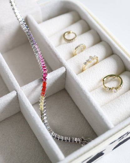 Jewelry box with rings and a bracelet on a light gray background