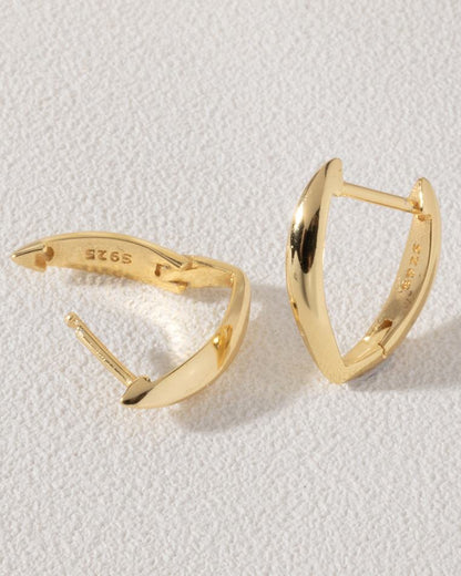 Gold hoop earrings on a light gray background
