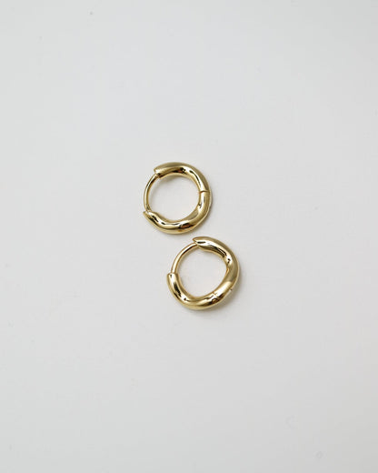 Pair of gold hoop earrings on a light gray background