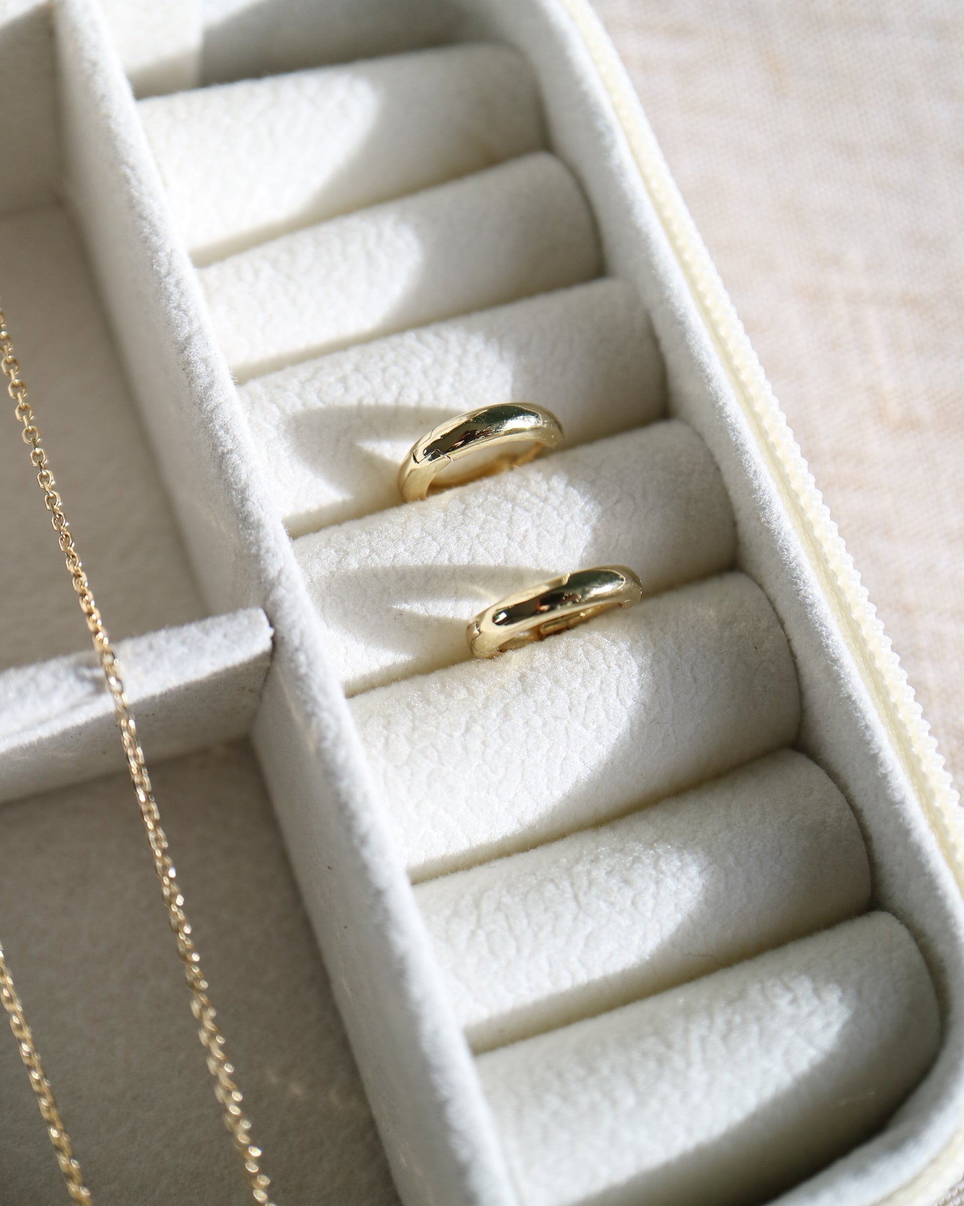 Gold ring in a jewelry box with a beige background