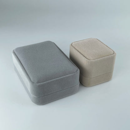 Grey velvet necklace box and nude velvet ring box, displayed side by side with lids closed