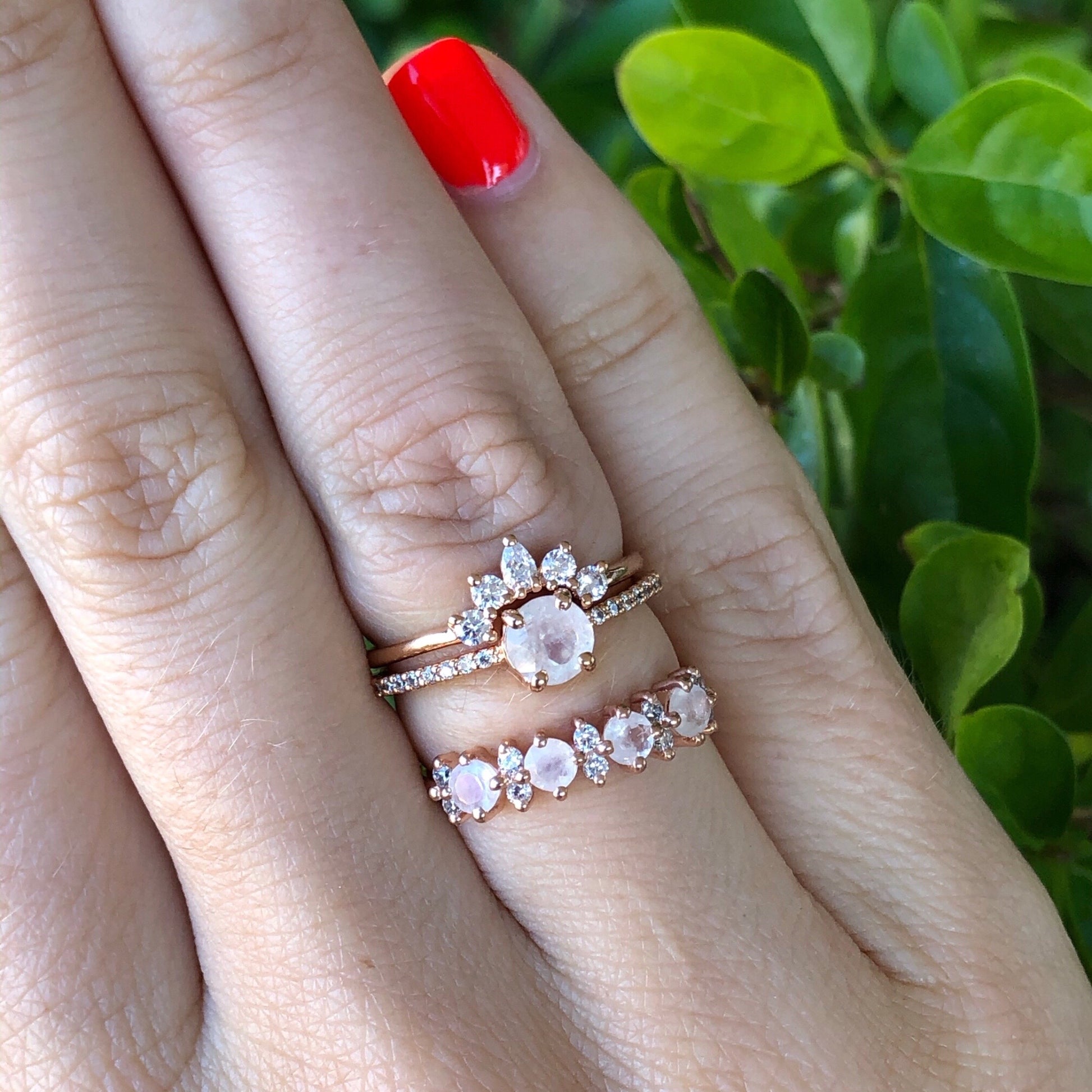 Rose gold ring band with natural rainbow moonstones and simulated diamonds, shown on hand