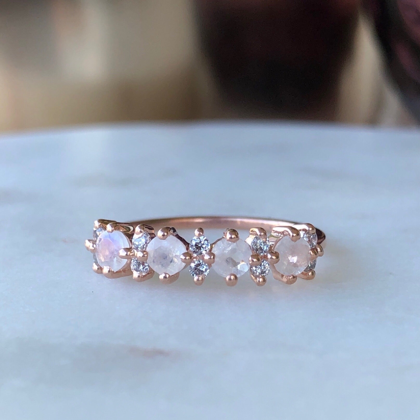 Rose gold band with simulated diamonds and rainbow moostones