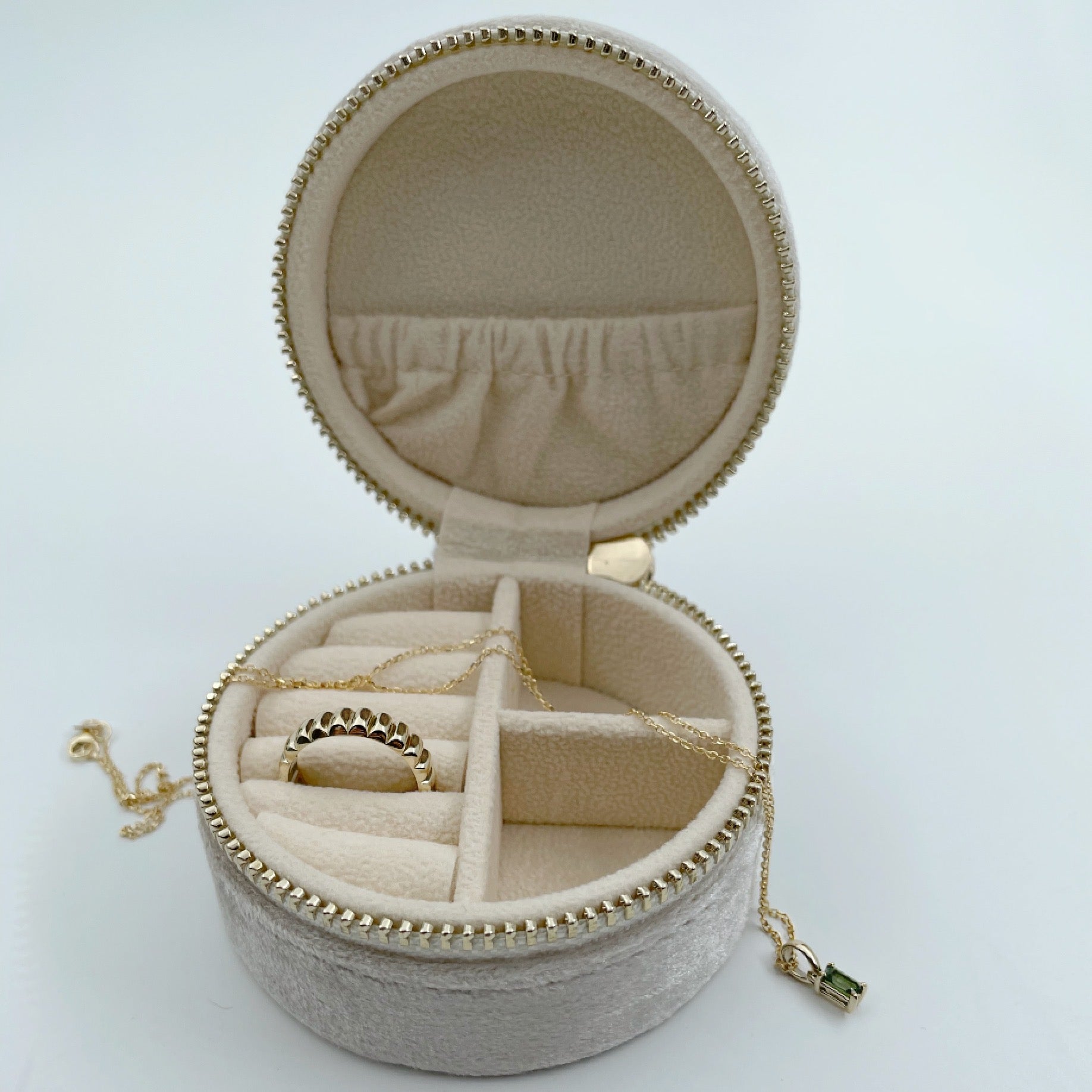 Round velvet jewellery case, open with jewelry inside