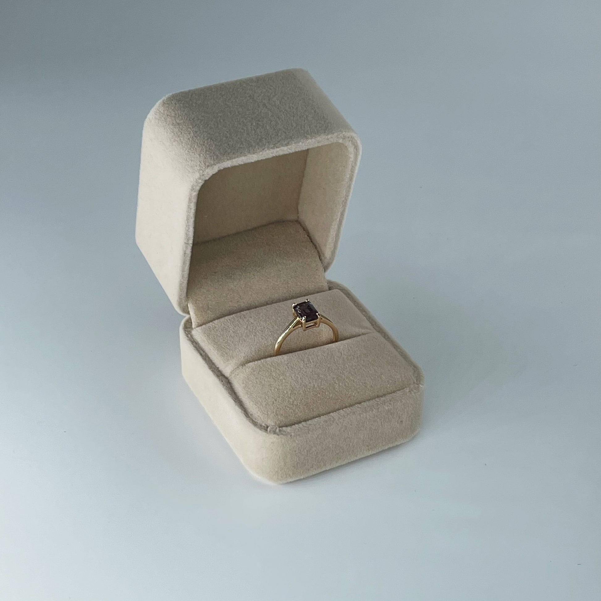 Nude coloured velvet ring box displayed open with La Kaiser Alexandrite Baguette ring inside