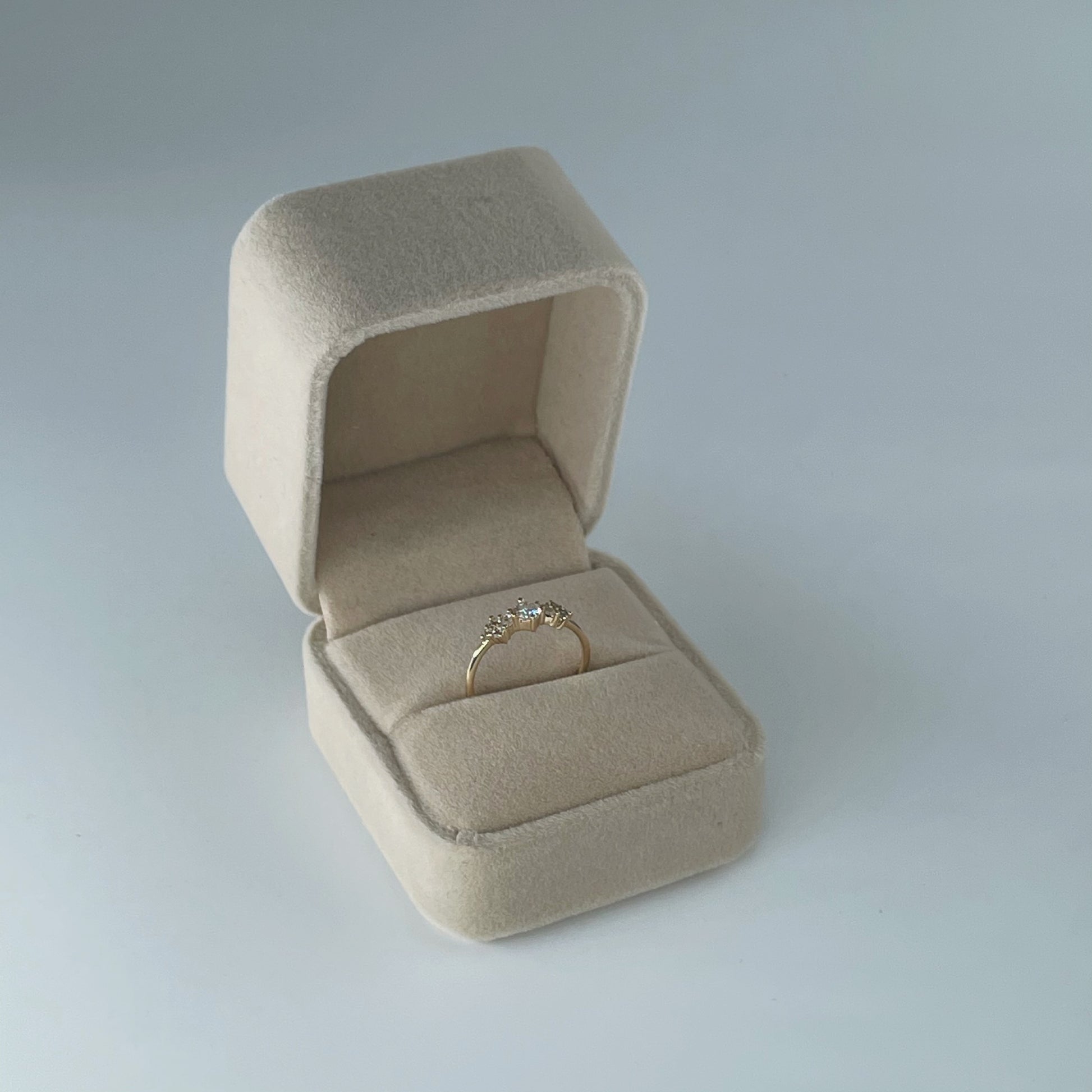 Velvet ring box in nude colour, displayed open with gold ring inside