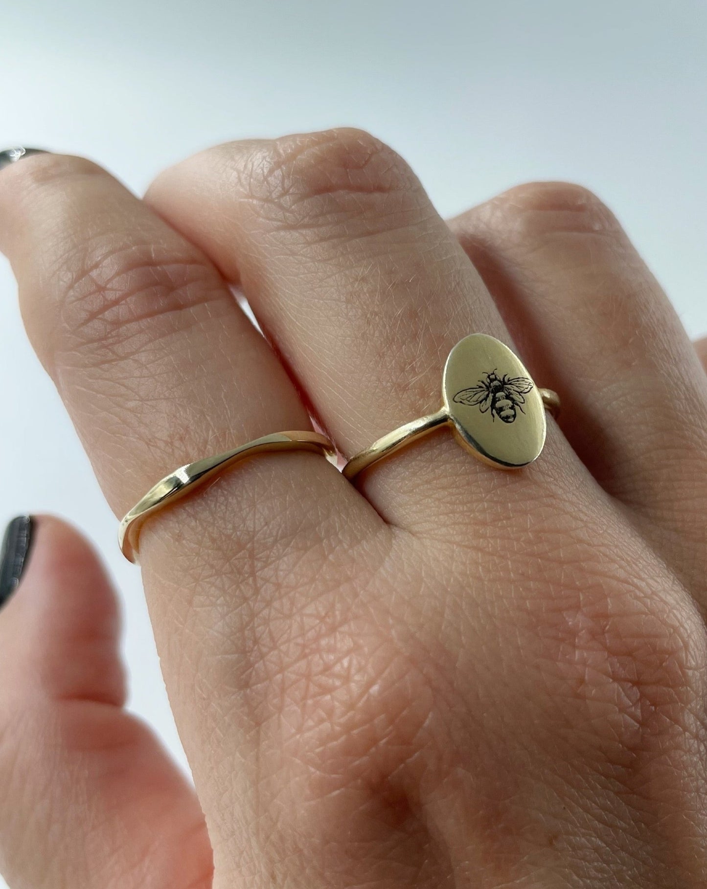 9ct wobble ring and 9ct gold bee ring shown on female hand